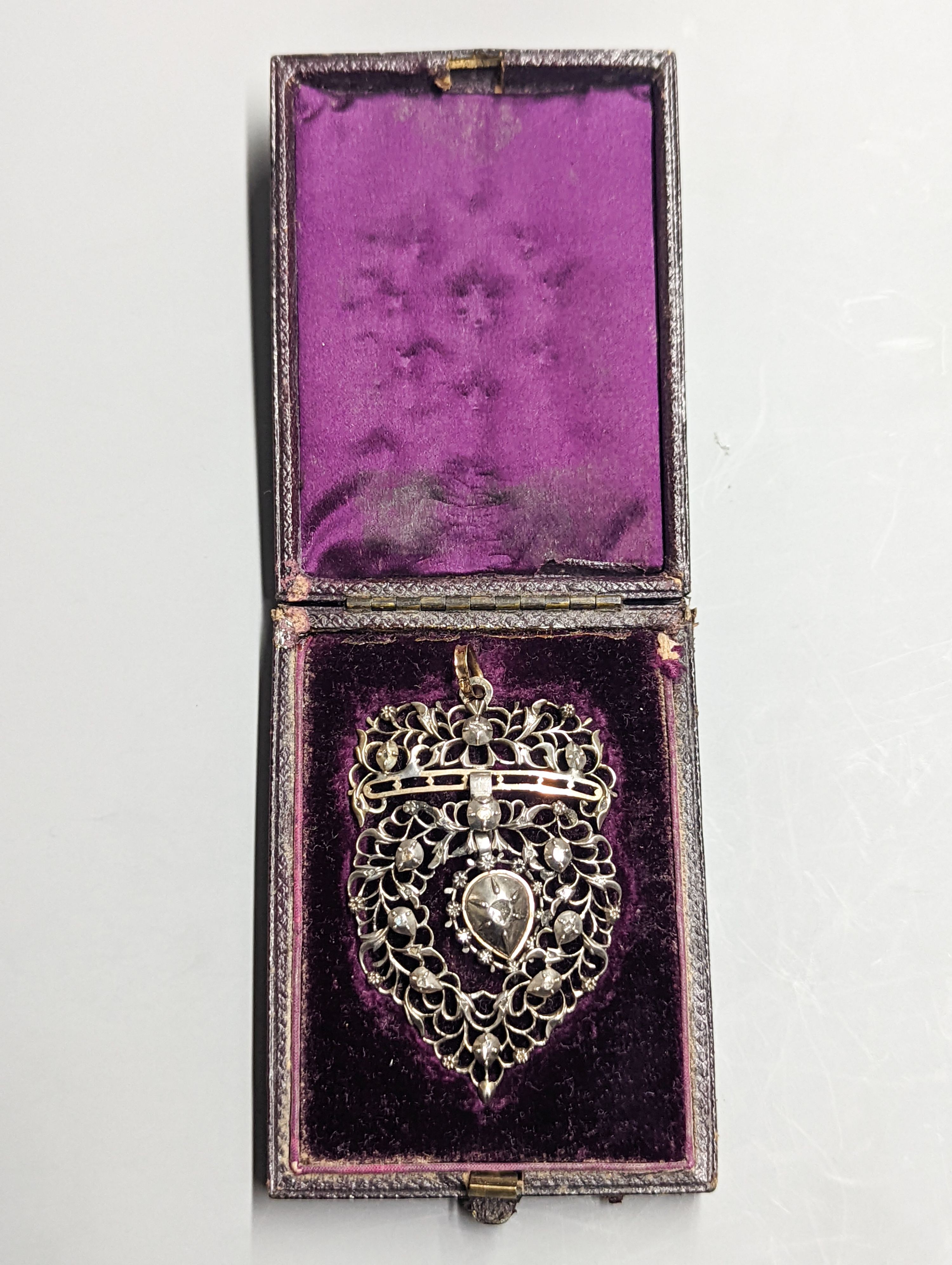 A late 19th century continental pierced white and yellow metal, rose cut diamond set heart shaped drop pendant, 62mm, gross weight 15.5 grams, in fitted box.